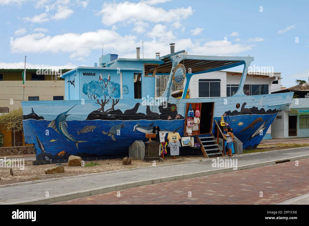 gift shop; old wood boat; decorated; marine life painting, blue, Wild Aid; brick street; Puerto Baquerizo Moreno; South America; Galapagos Islands, Sa Stock Photo