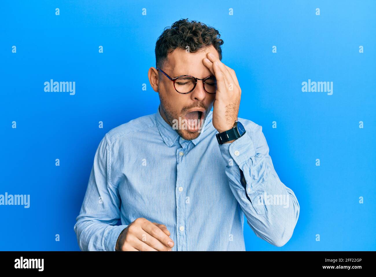 Young hispanic man wearing casual clothes and glasses yawning tired