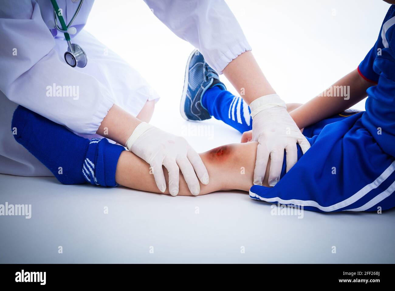 Youth soccer player's knee with a bruise, left knee bruise. Doctor