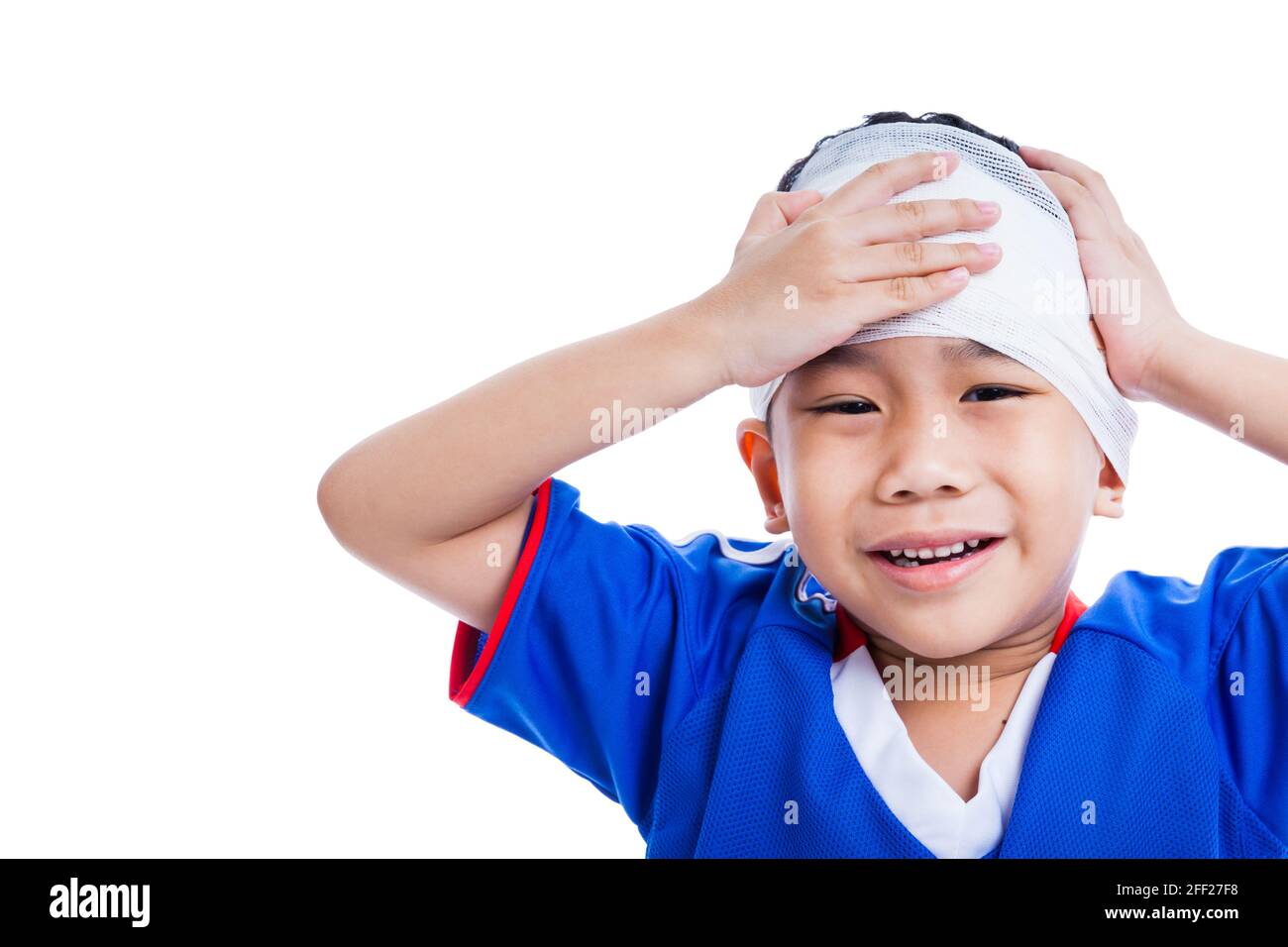 Sports injury. Youth athlete asian child with trauma of the head painful crying and touching his forehead.  Boy has bandage on head, free form copy sp Stock Photo
