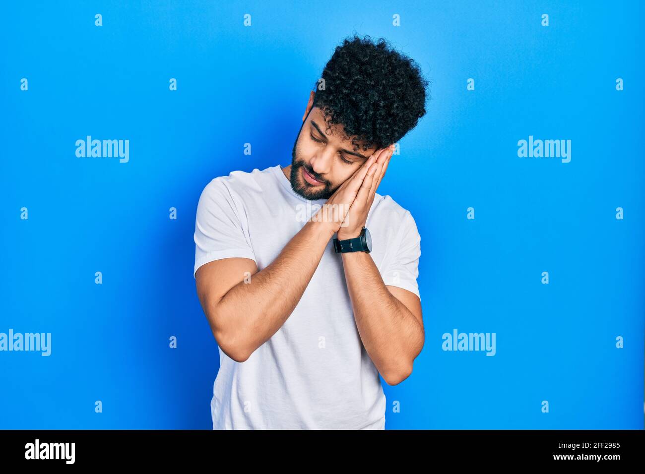Young arab man with beard wearing casual white t shirt sleeping tired ...