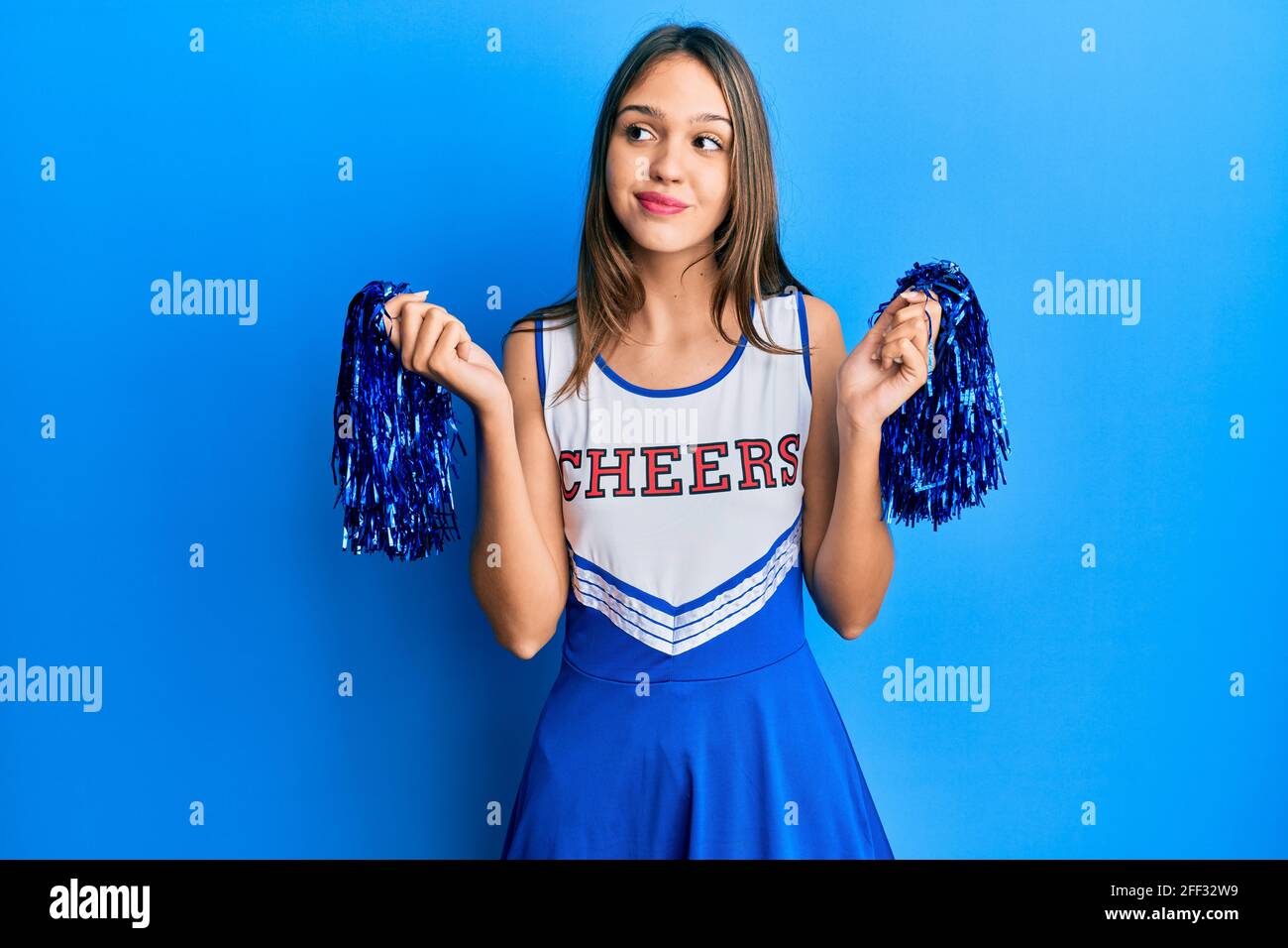 Young brunette woman wearing cheerleader uniform smiling looking to the  side and staring away thinking Stock Photo - Alamy