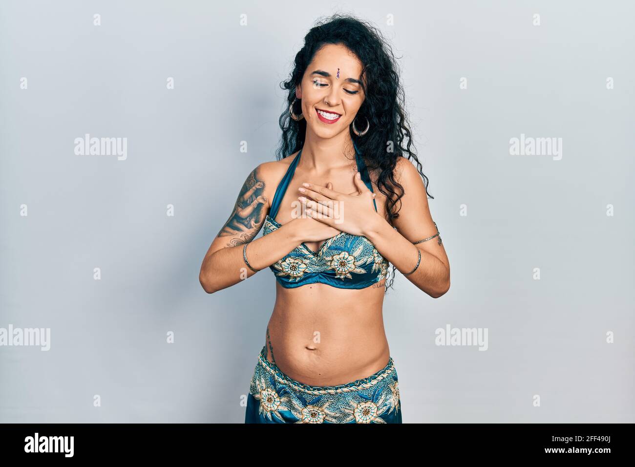 Young woman wearing bindi and traditional belly dance clothes smiling with  hands on chest with closed eyes and grateful gesture on face. health concep  Stock Photo - Alamy