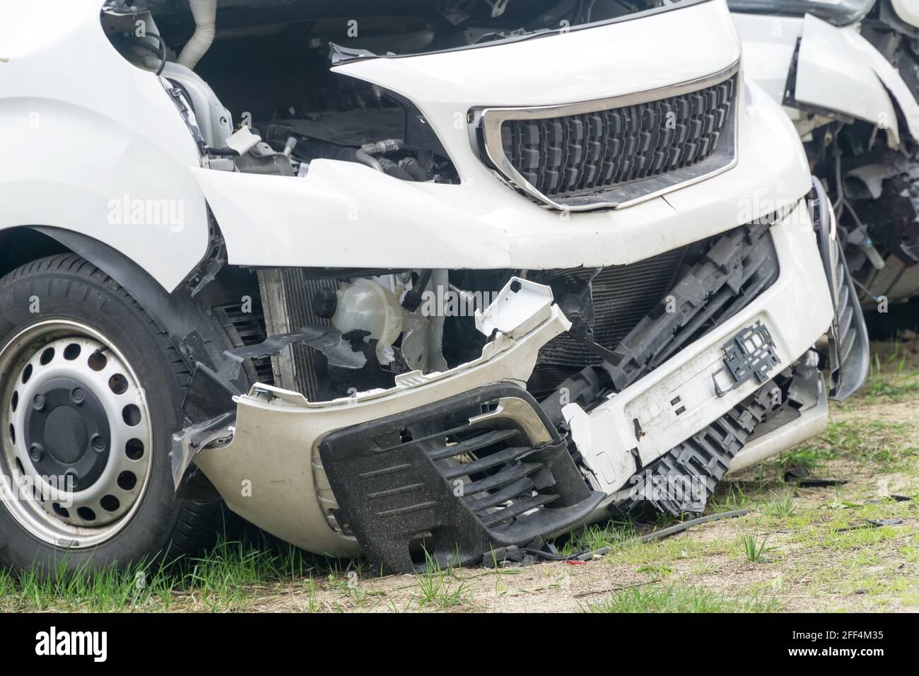 Broken car white van after frontal collision. Closeup. Stock Photo