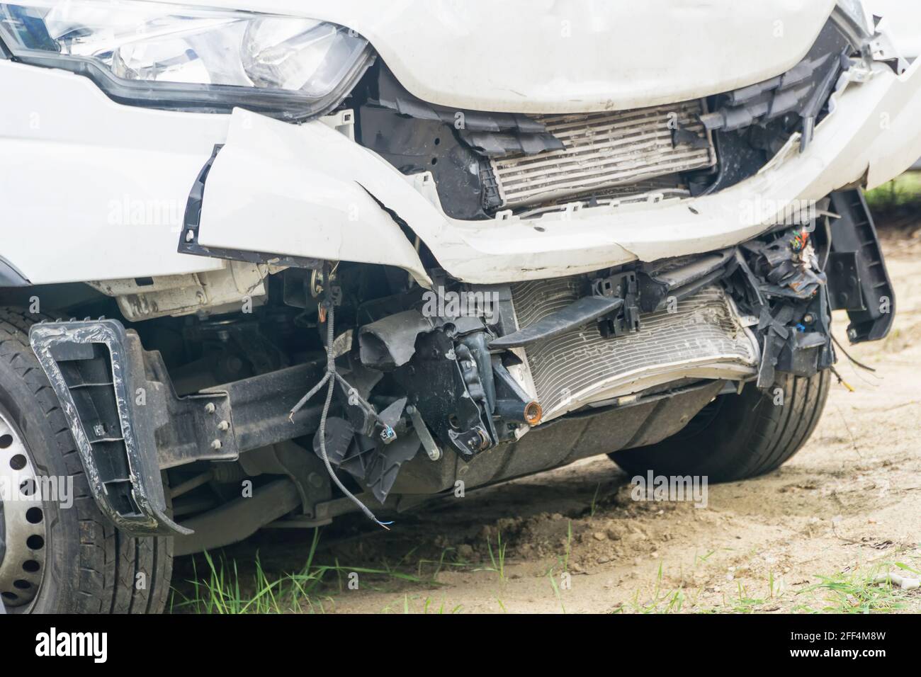 Broken car white van after frontal collision. Closeup. Stock Photo