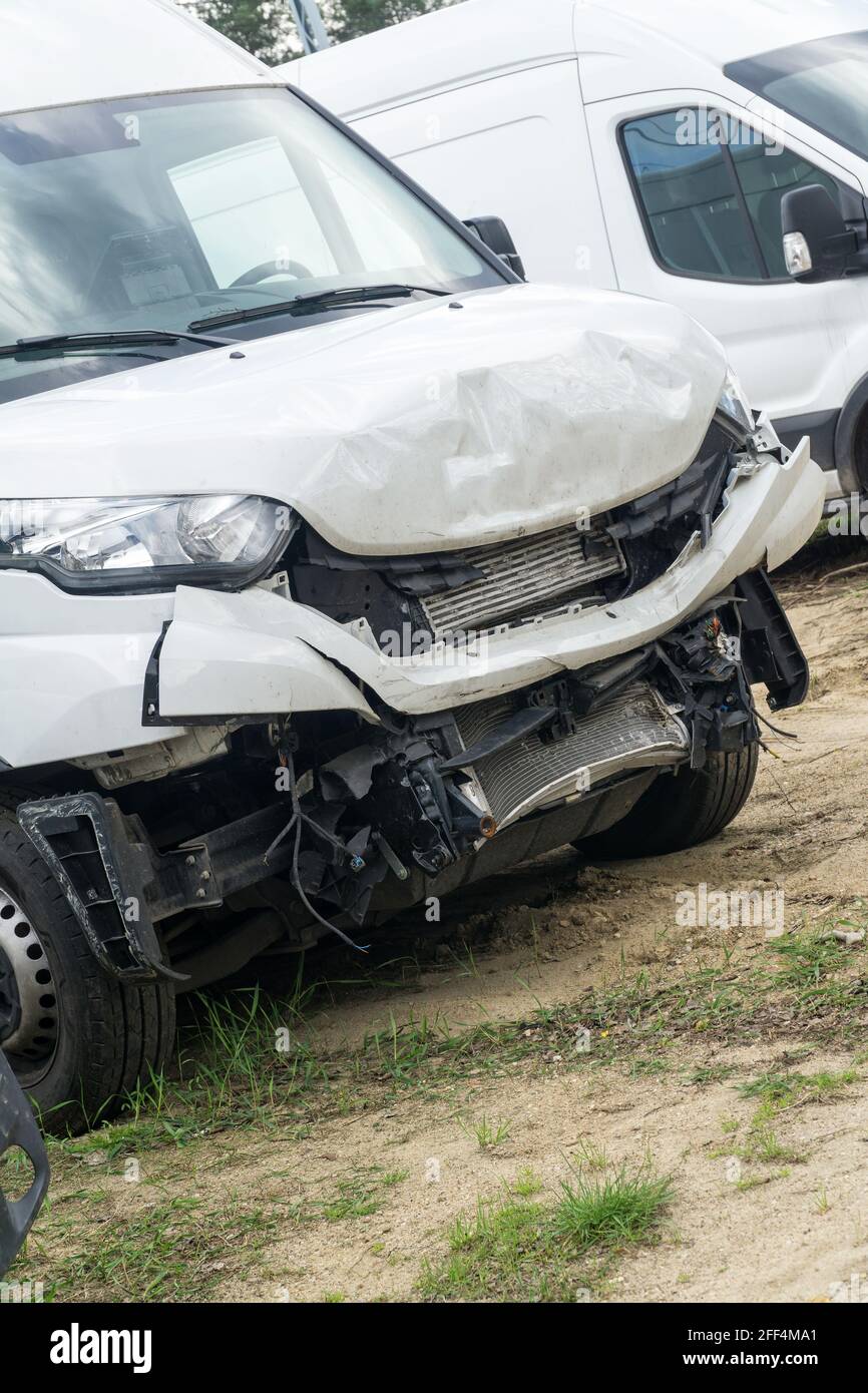 Broken car white van after frontal collision. Closeup. Stock Photo