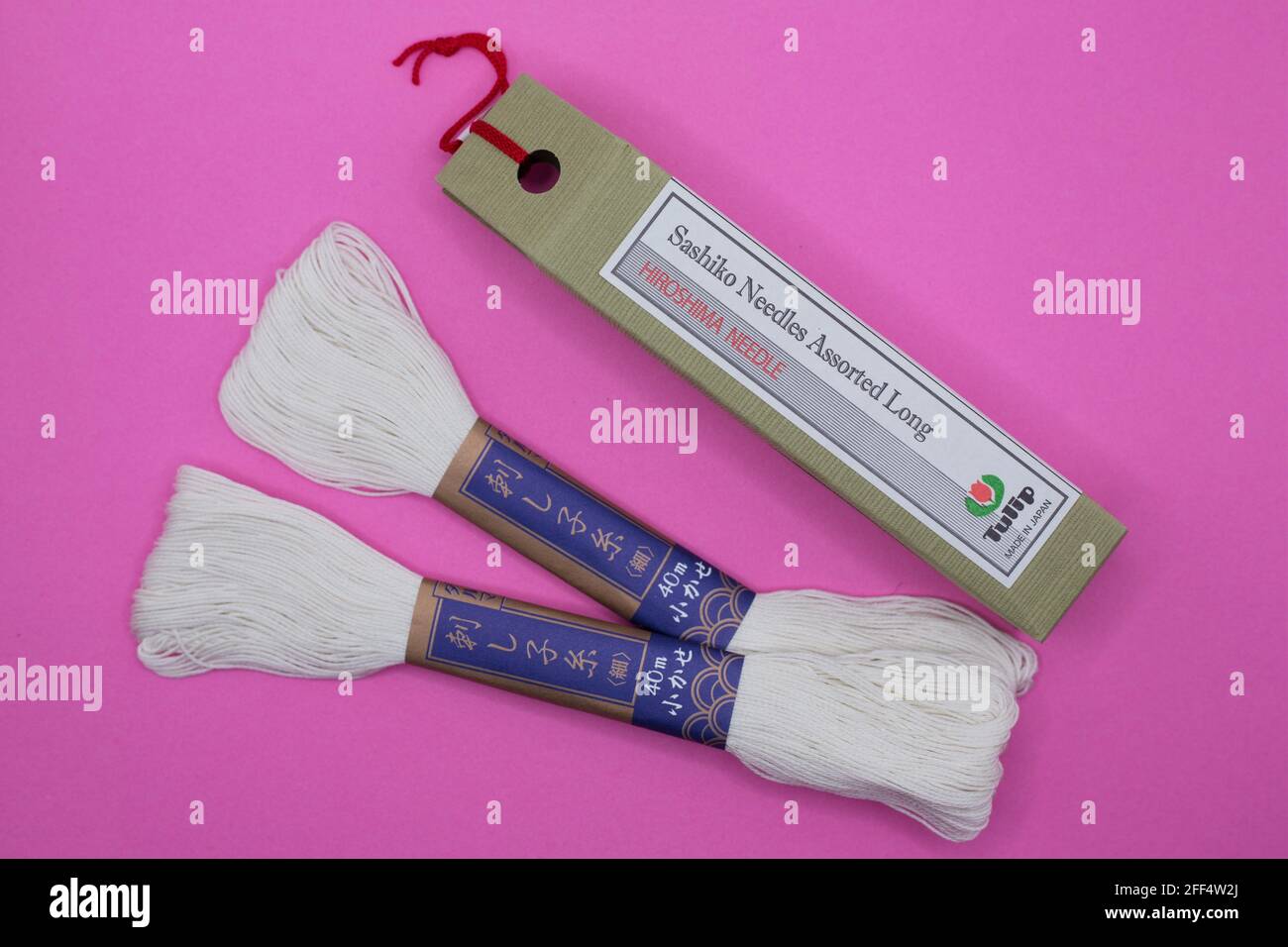 Sashiko Japanese embroidery needle and thread on a pink background