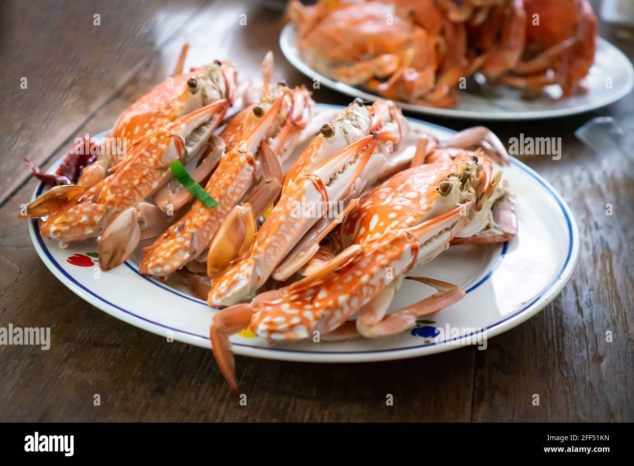 Top view Boiled Crabs and Shrimps in the white ceramic and glass dish on the vintage wooden table. Stock Photo