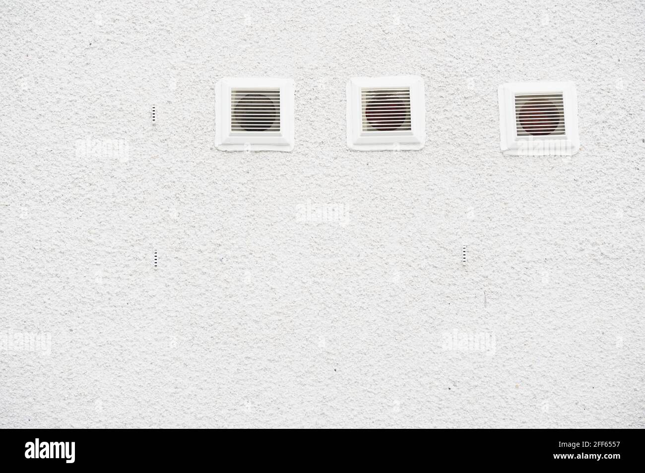 White plastic air vents on plain background house wall Stock Photo