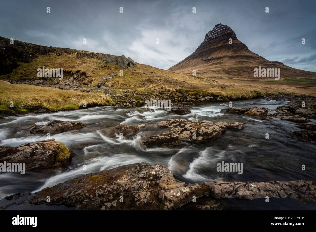 Kirkjufellsfoss waterfall and Kirkjufell mountain, in Snaefells…