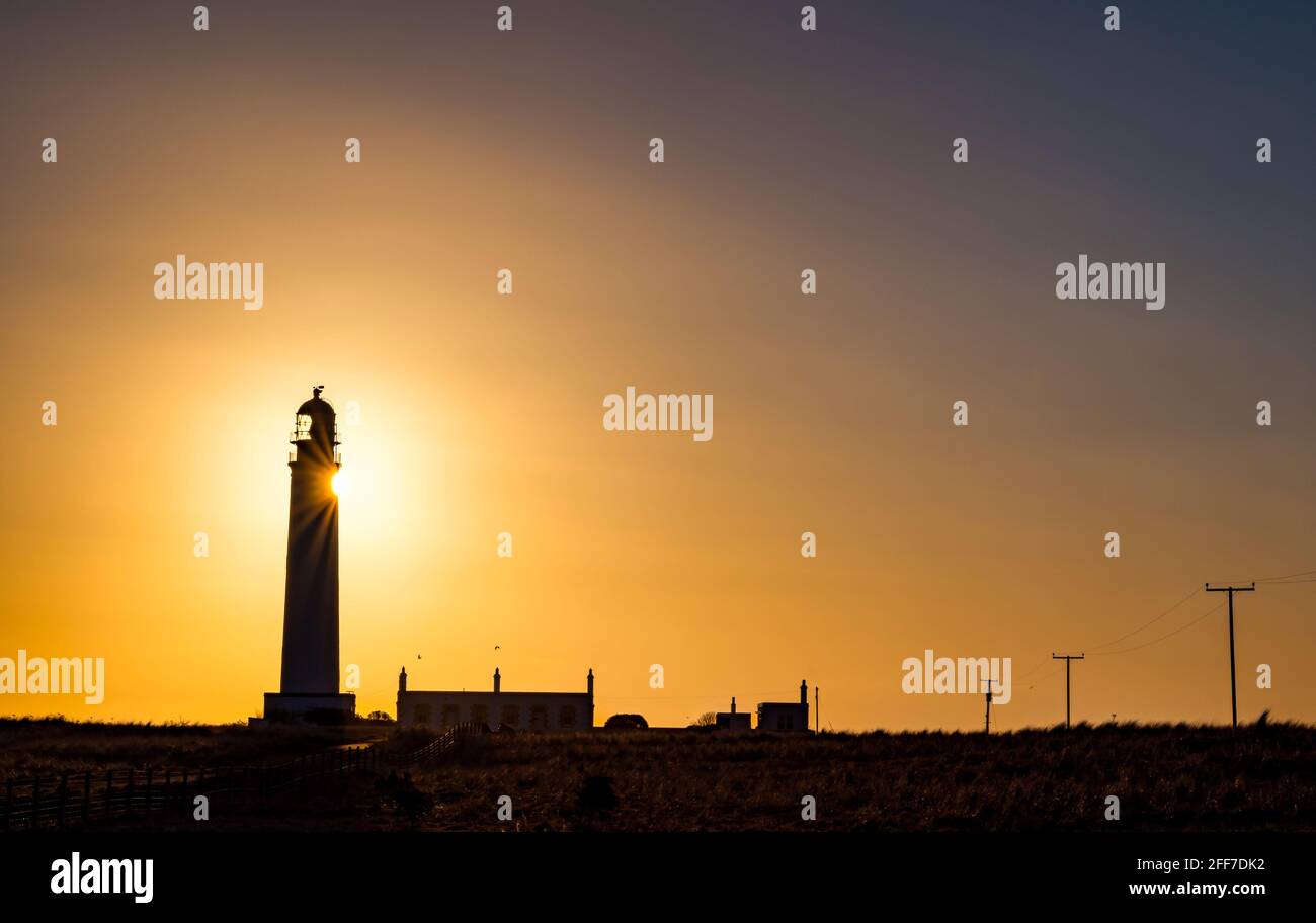 Barns Ness Lighthouse at dawn sunrise sunburst and colourful sky, East Lothian, Scotland, UK Stock Photo