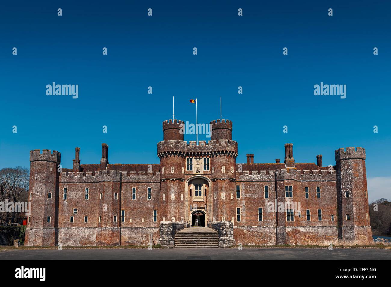 Herstmonceux Castle, East Sussex, UK. One of the oldest significant brick buildings still standing in England. Flying Queen's University (Canada) Flag Stock Photo