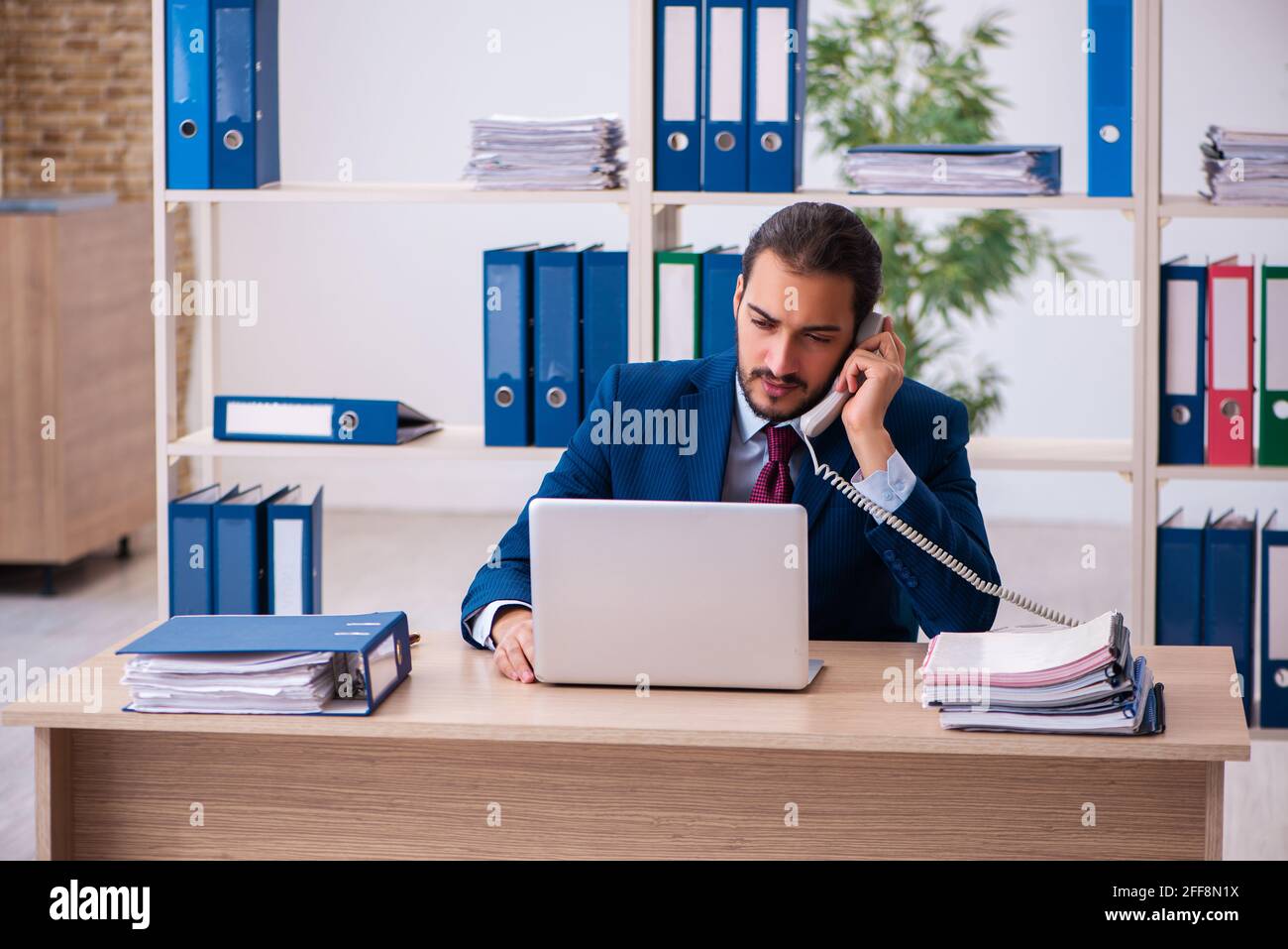 Young employee and too many work in the office Stock Photo - Alamy