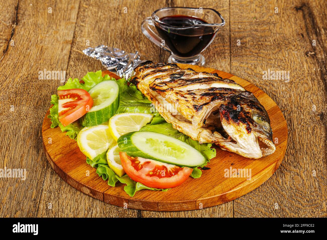 Grilled dorada fish with sauce and vegetables Stock Photo - Alamy