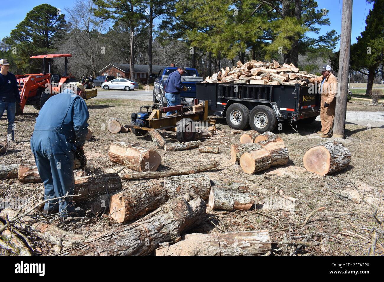 Men cutting logs to be split into firewood Stock Photo Alamy
