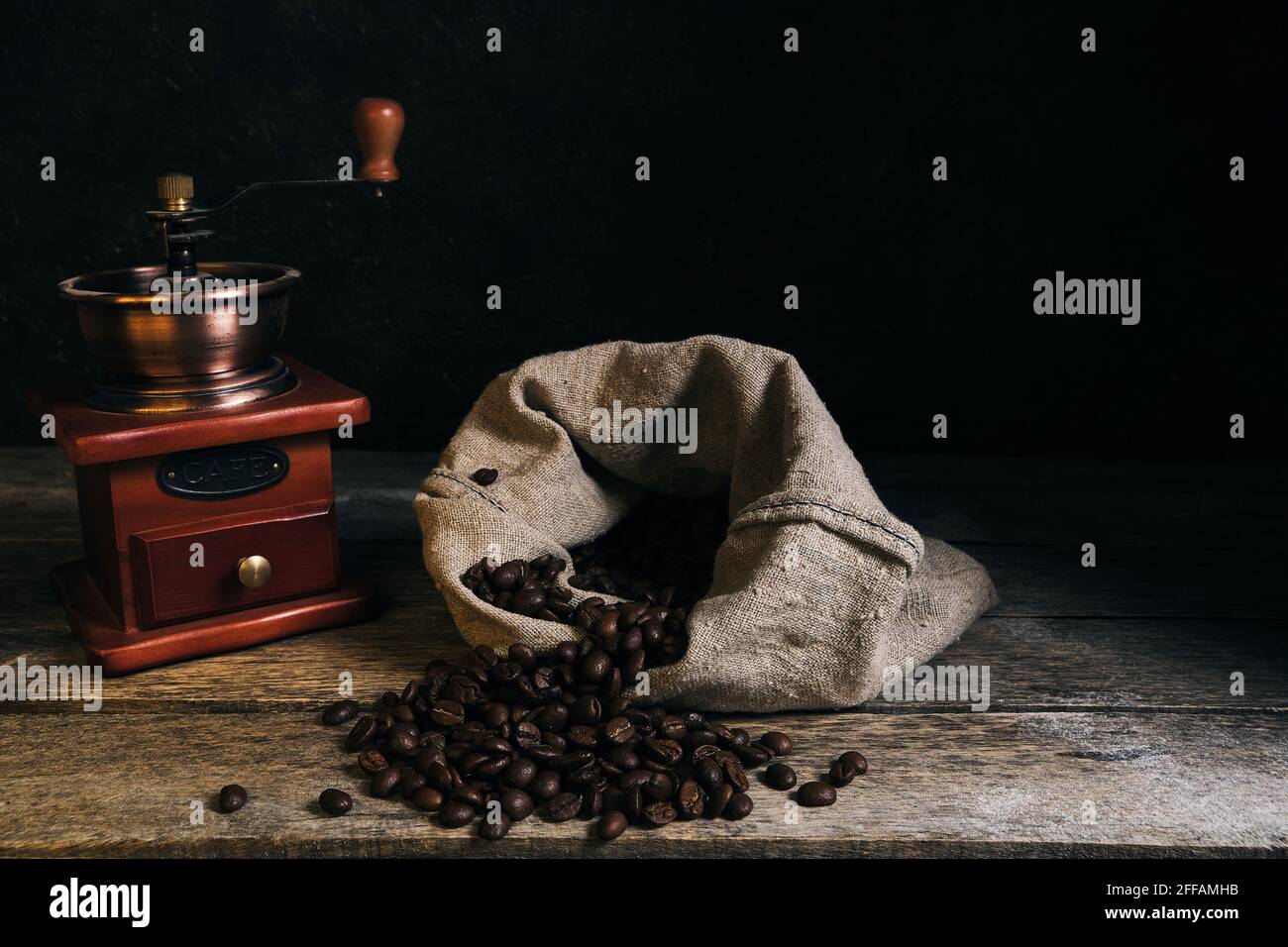 Roasted coffee beans in bag and coffee grinder on an old wooden table ...