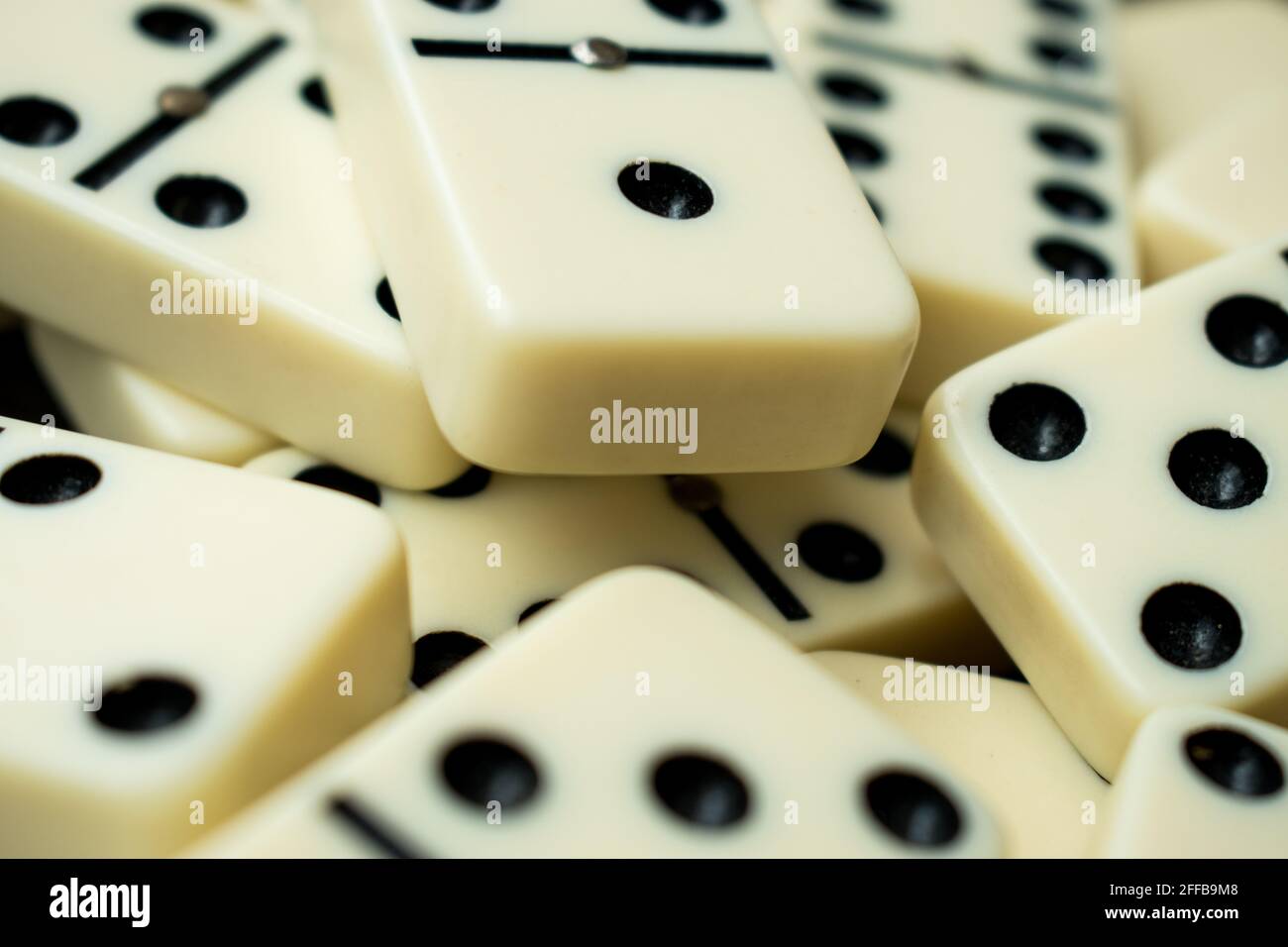 Close up of some white dominoes with  black points on a black table Stock Photo