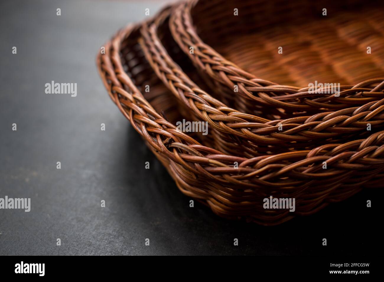 Some brown handmade baskets on a black wooden table Stock Photo