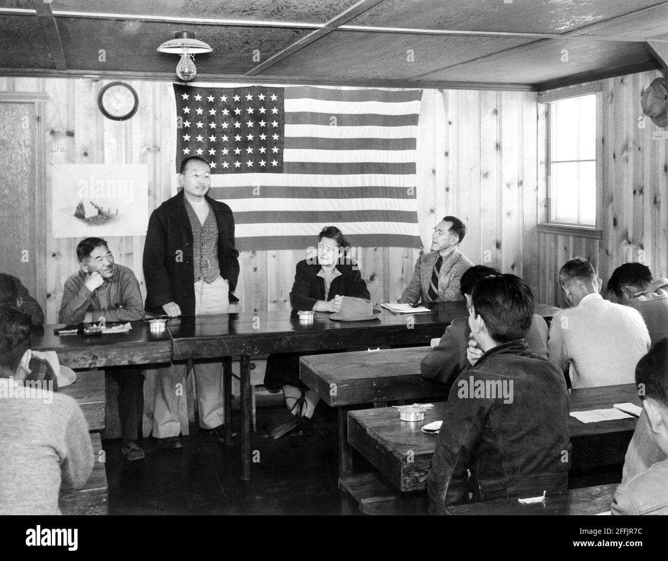 Roy Takeno (standing), addressing group of people at Town Hall Meeting, Manzanar Relocation Center, California, USA, Ansel Adams, Manzanar War Relocation Center Collection, 1943 Stock Photo