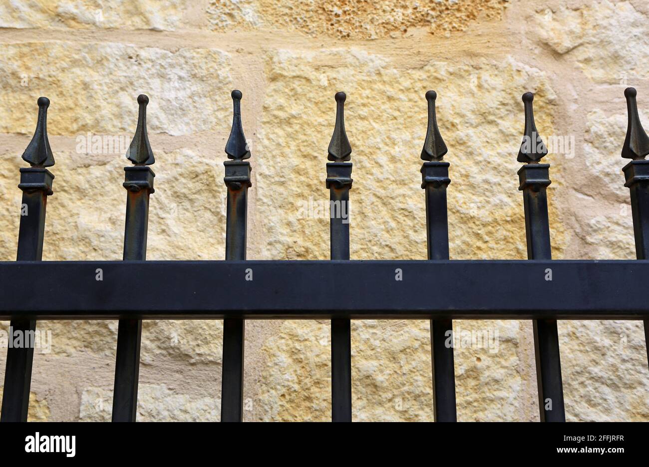 Iron fence on sandstone wall background San Antonio, Texas Stock