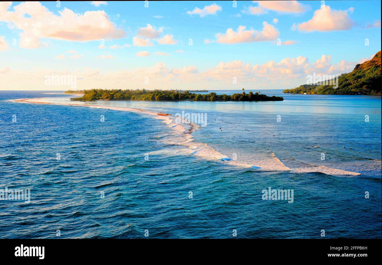 The beautiful warm water around the Polynesian Islands in the South Seas of the Pacific Ocean on a sunny day with blue skies and white clouds.. Stock Photo