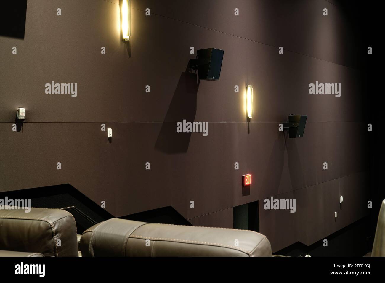 Upholstered interior movie theater wall with speakers low lit