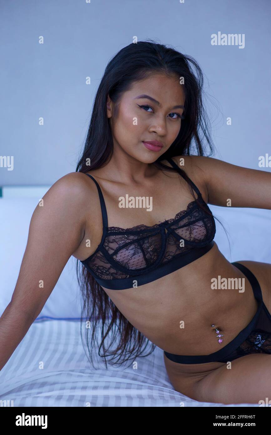 SEXY ASIAN GIRL ON BED IN BLACK LINGERIE Stock Photo