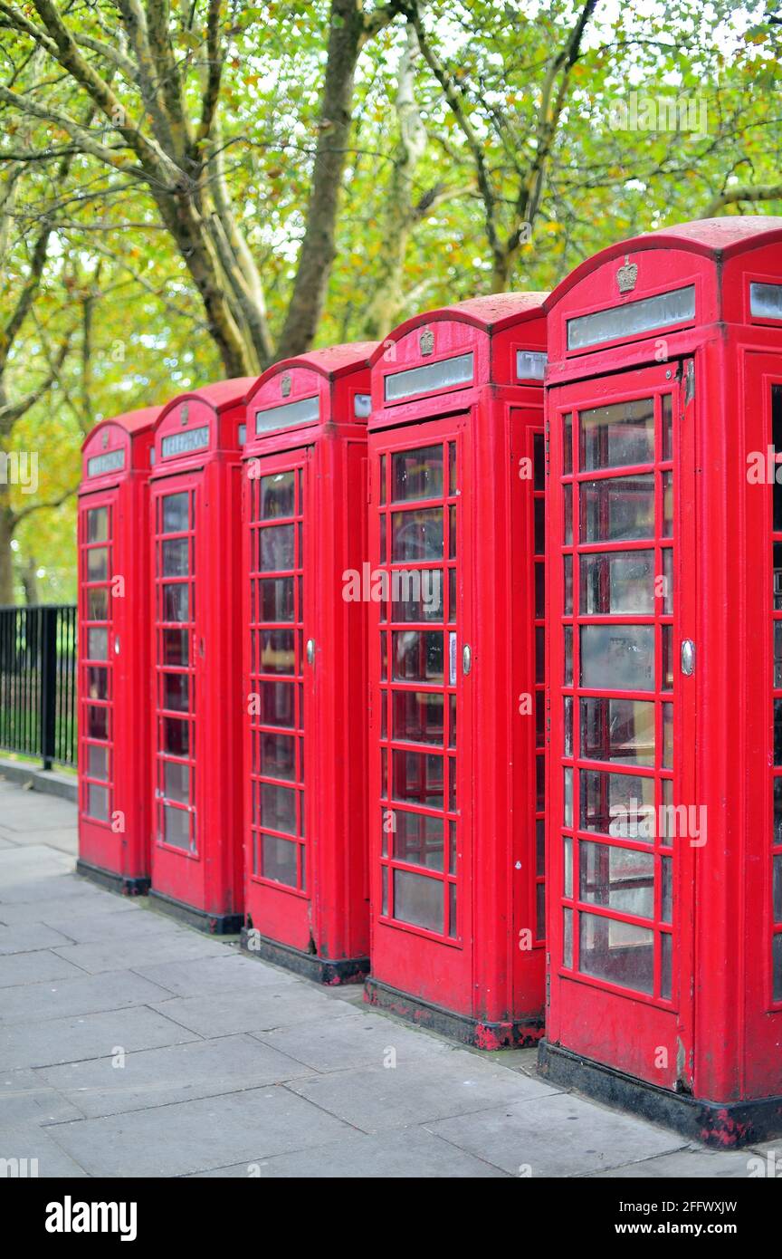 London, England, United Kingdom. A bank of traditional red telephone boxes along Park Lane on the edge of Hyde Park in London's West End. Stock Photo