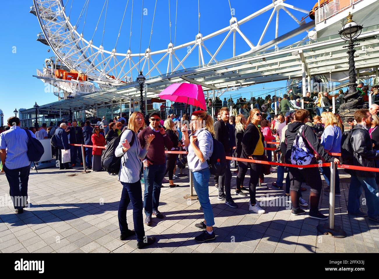 London, England, United Kingdom. Long lines of tourists waiting to ride the London Eye Ferris wheel on the South Bank of the River Thames. Stock Photo