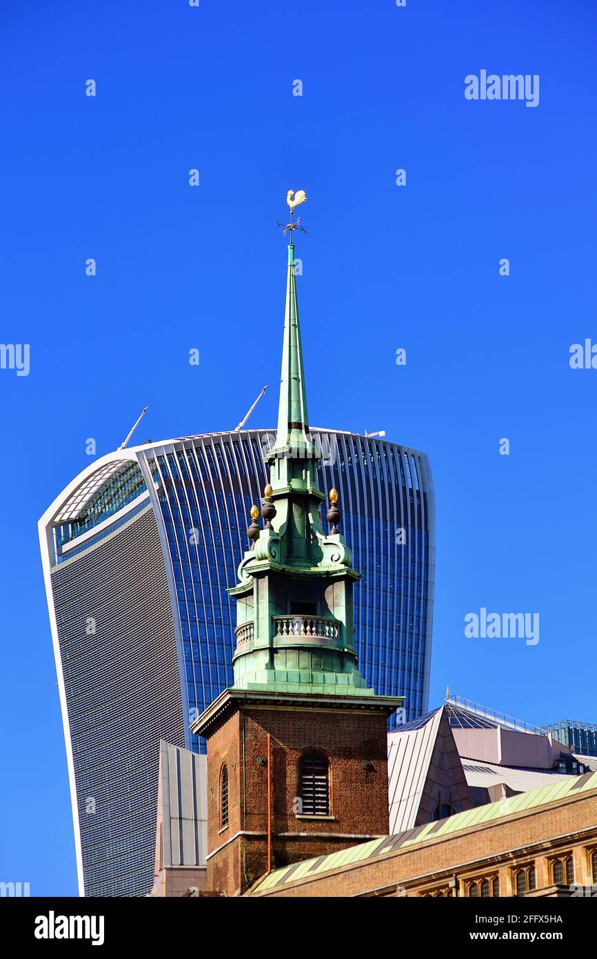 London, England, United Kingdom. An architectural contrast existing in the City of London. In the foreground the steeple of All Hallows by the Tower. Stock Photo