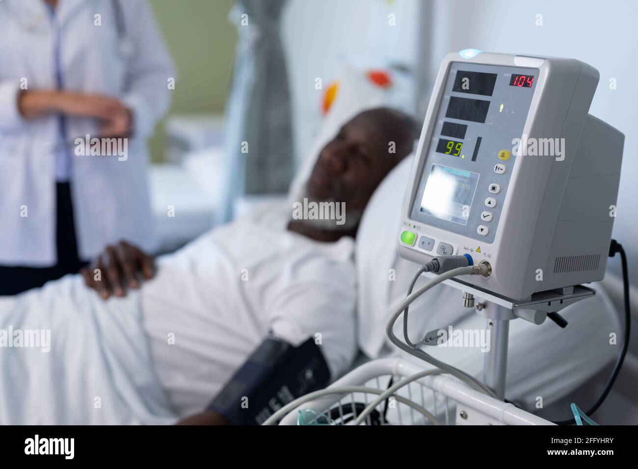 African american male patient lying on hospital bed next to blood