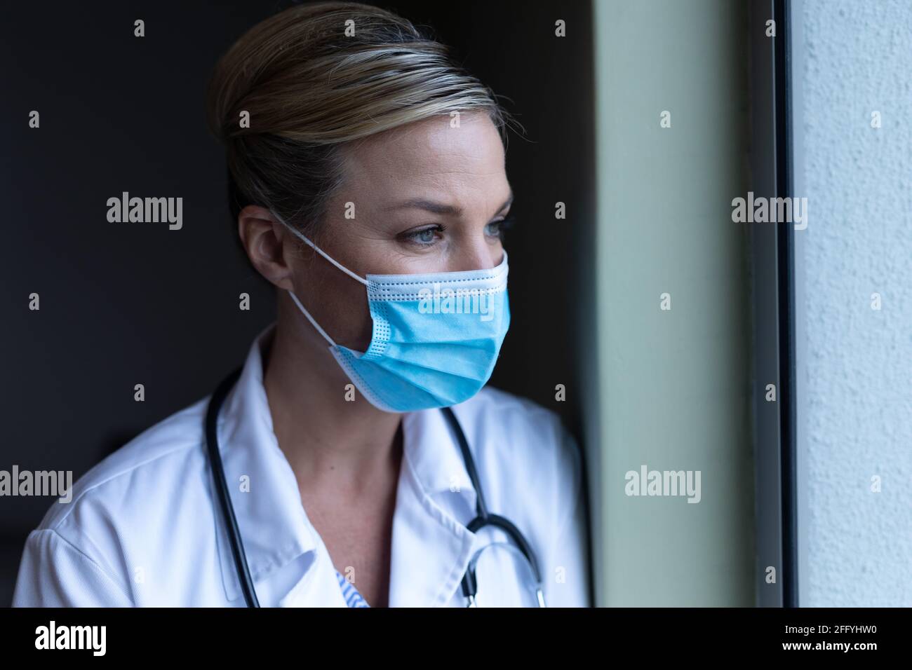 Portrait of caucasian female doctor wearing mask looking ahead Stock Photo