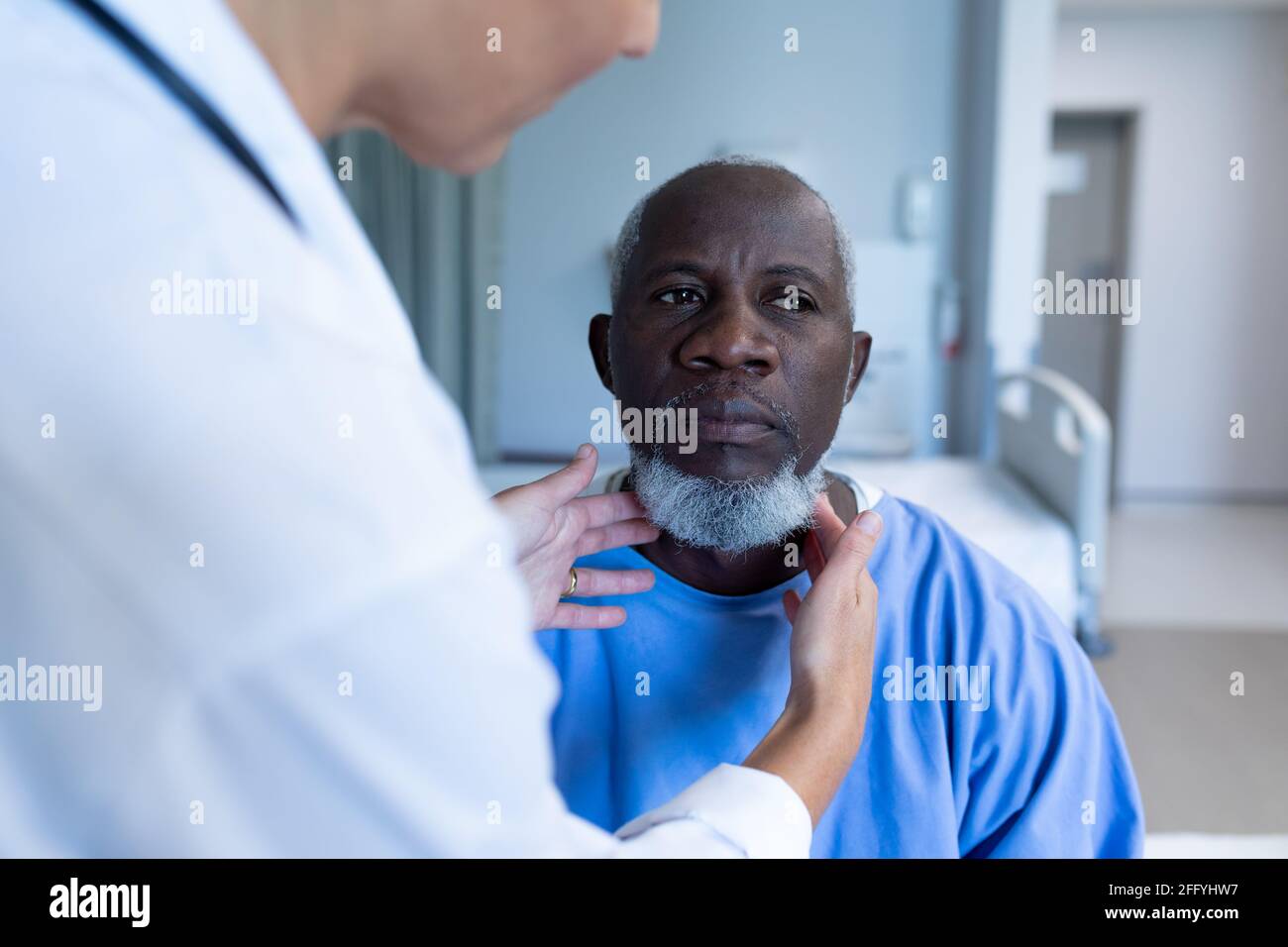 Caucasian female doctor palpating lymph nodes of african american male patient Stock Photo