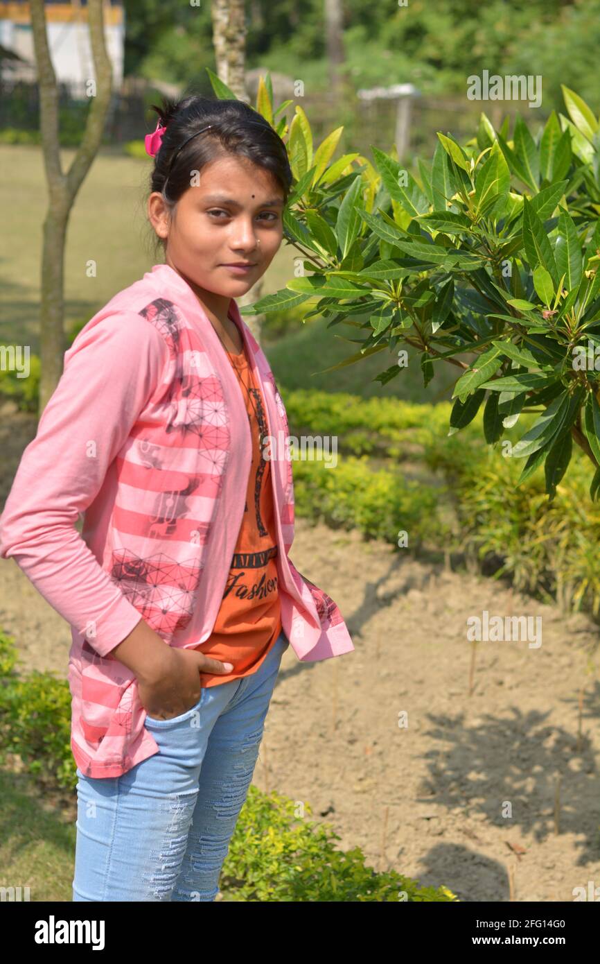Teenage Indian Bengali girl wearing jeans hands on pocket posing for photo in a garden, selective focusing Stock Photo