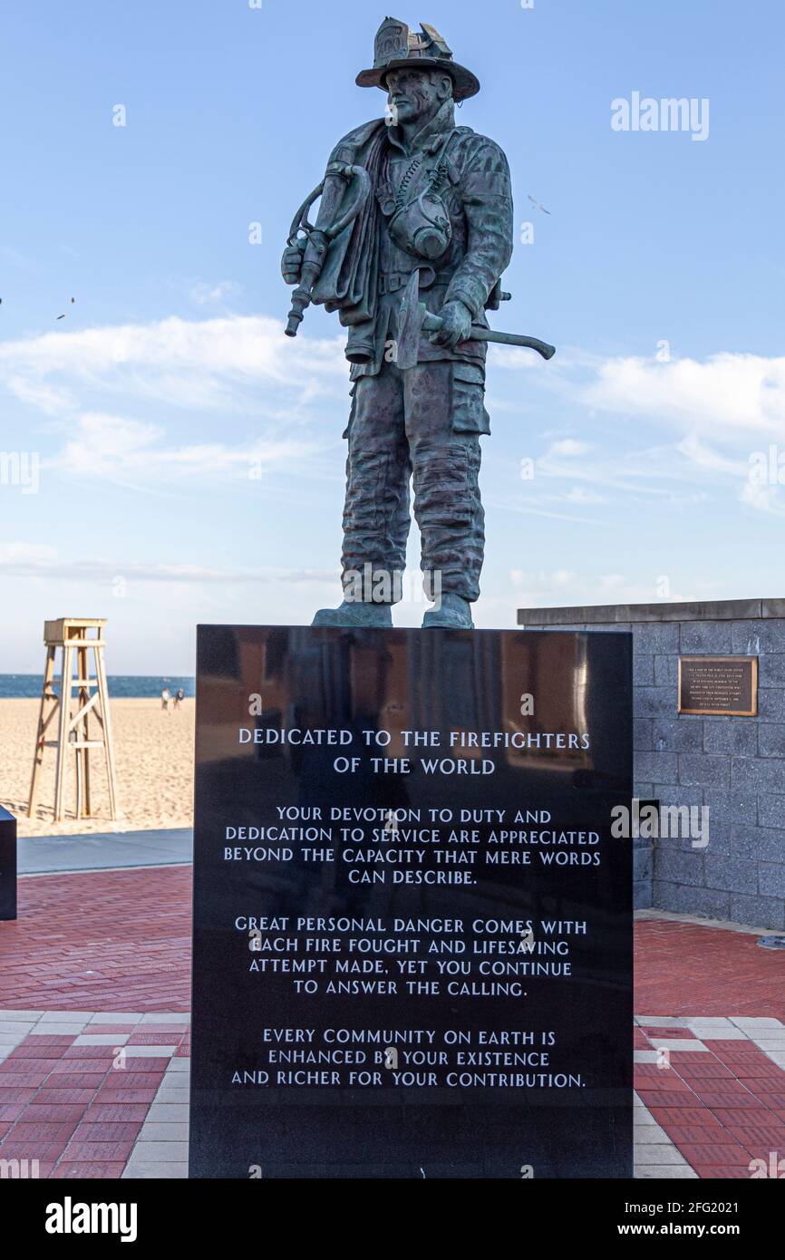 Ocean City, MD, USA 04-18-2021: Figherfigher statue featuring a fire and rescue team personel with full gear and a hose. Dedicated to the firefighters Stock Photo
