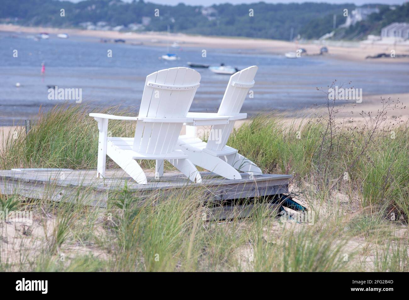 Two wooden beach chairs at the shore on Cape Cod in Wellfleet MA Stock