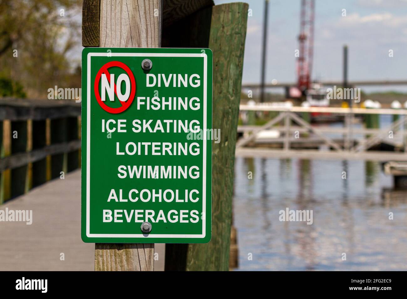 An extensive list of actions forbidden on the dock area are shown. The sign says no to diving, swimming, ice skating, loitering, fishing and alcoholic Stock Photo