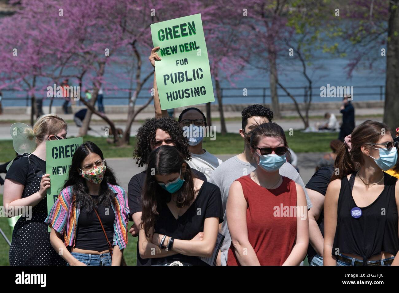 NEW YORK, NY - APRIL 24: A man holds a sign that reads 'Green New Deal for Public Housing' seen during an Earth Day Celebration in Astoria Park on April 24, 2021 in the Astoria neighborhood of the Queens borough of New York City.   Congresswoman Ocasio-Cortez joined by New York State Senator Jessica Ramos and New York Assembly Member Zohran Mamdani for remarks about the NRG Energy, Inc proposal for the Astoria power plant. re Credit: Ron Adar/Alamy Live News Stock Photo