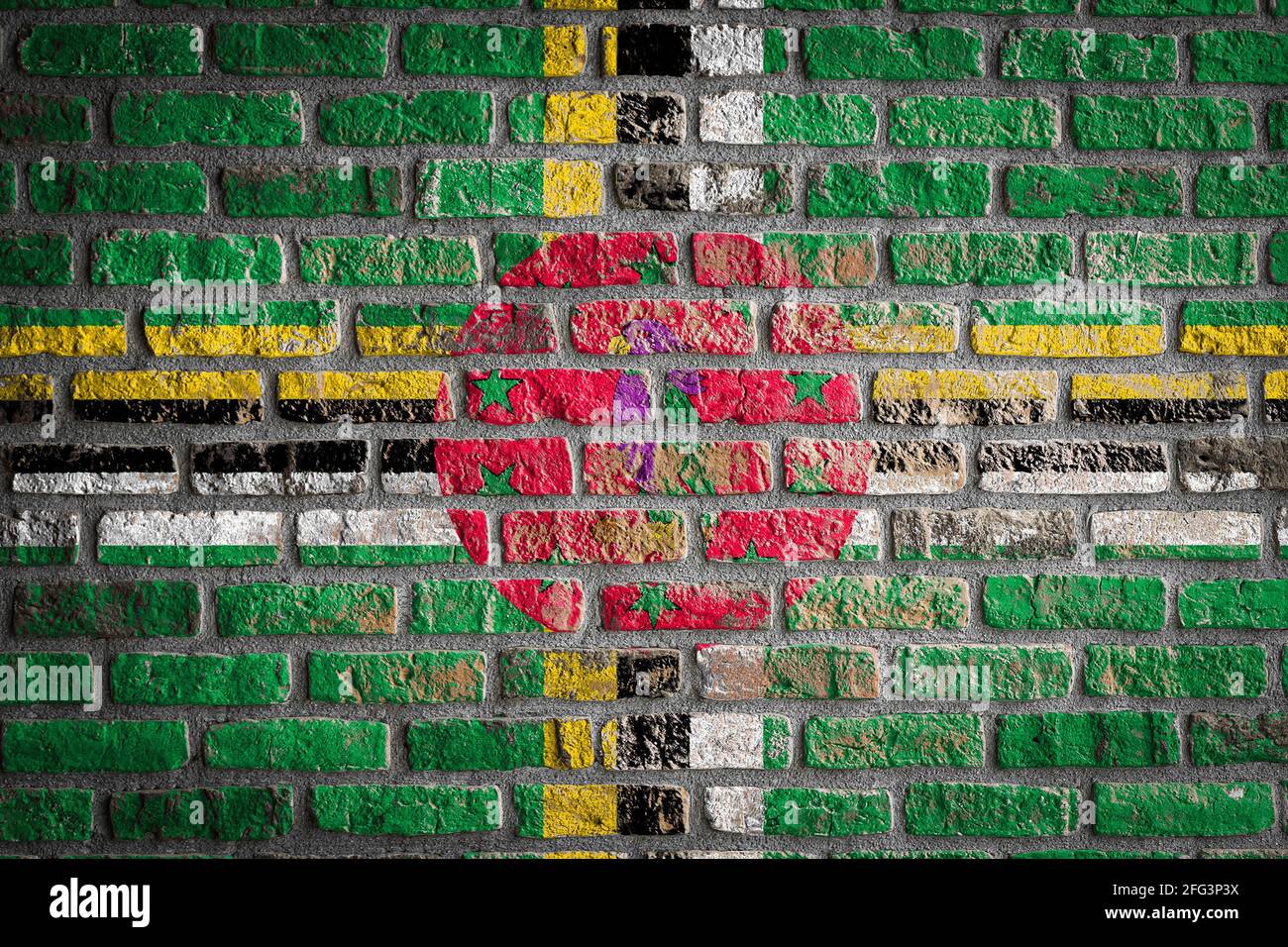 National flag of Dominica depicting in paint colors on an old brick ...