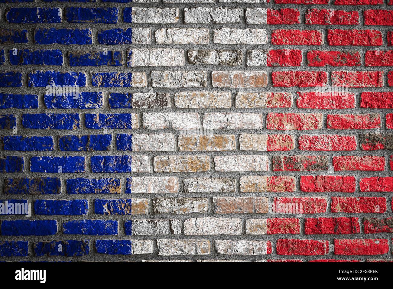 National flag of France depicting in paint colors on an old brick wall ...