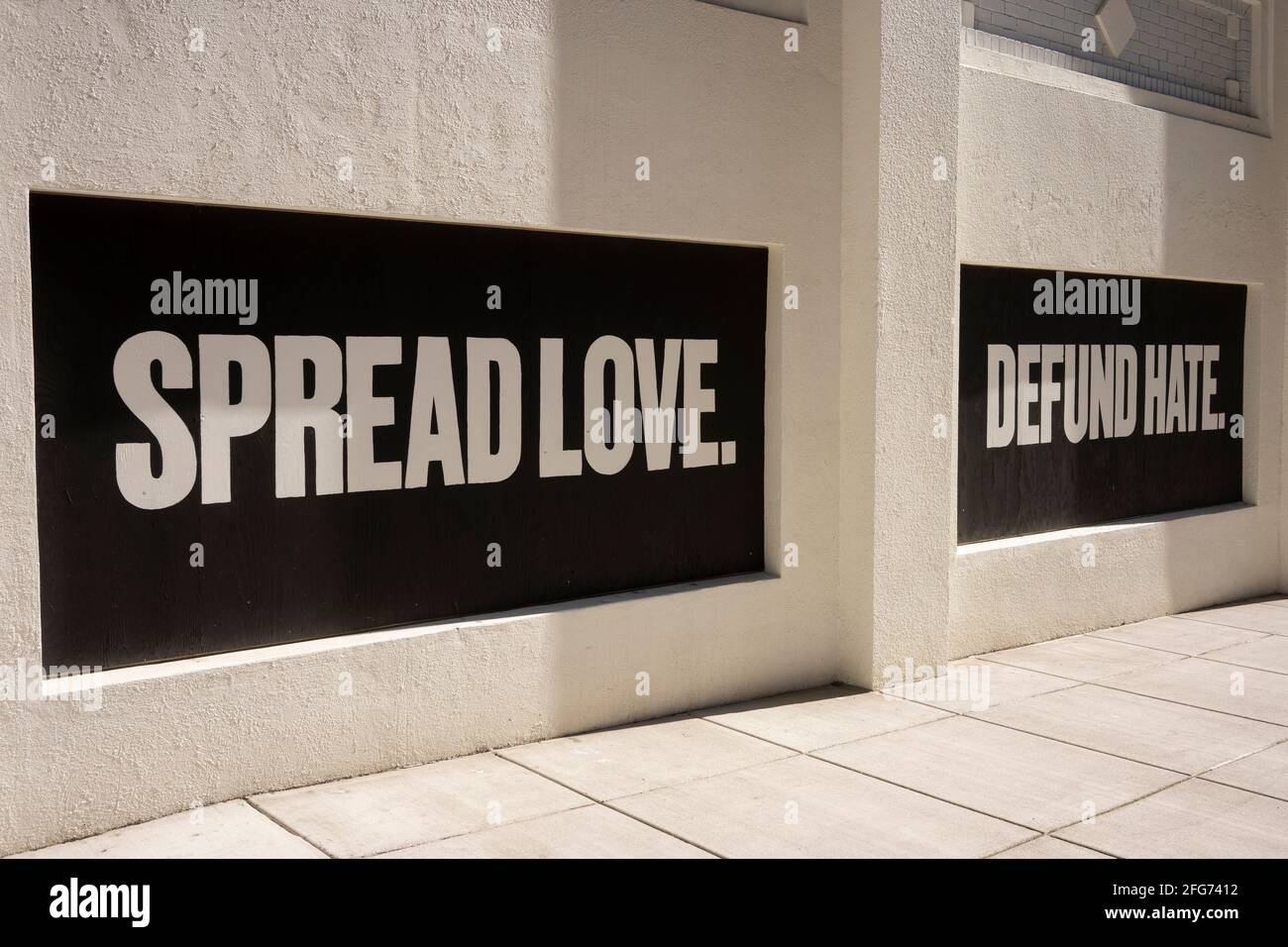 Spread Love. Defund hate. Positive slogans are seen on boarded-up windows of the Multnomah County Central Courthouse building on April 18, 2021, amid ... Stock Photo