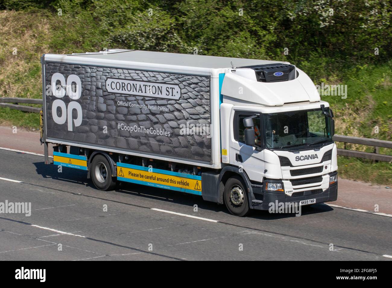 Co-op specially branded delivery trucks; Coop lorry, heavy-duty vehicles, transportation, food groceries truck, Coronation Street cargo carrier, Scania vehicle, European commercial transport industry HGV, M6 at Manchester, UK Stock Photo