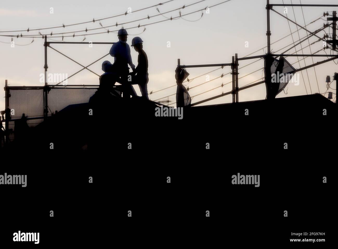 Men working on roof at construction site Stock Photo