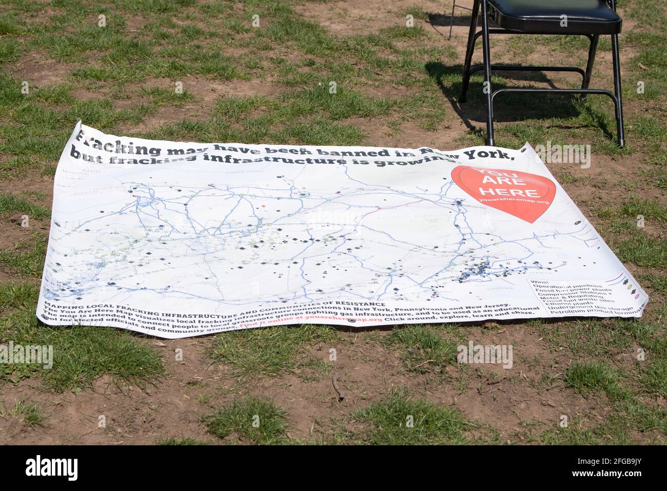 A Banner showing fracking infrastructure during an Earth Day Celebration in Astoria Park of the Queens borough of New York City.Congresswoman Ocasio-Cortez joined by New York State Senator Jessica Ramos and New York Assembly Member Zohran Mamdani for remarks about the NRG Energy, Inc proposal for the Astoria power plant. The Congresswoman opposes NRG's effort to replace their 50-year old turbine at the Astoria 'peaker' plant with a generator that burns fossil fuels extracted by fracking. (Photo by Ron Adar/SOPA Images/Sipa USA) Stock Photo