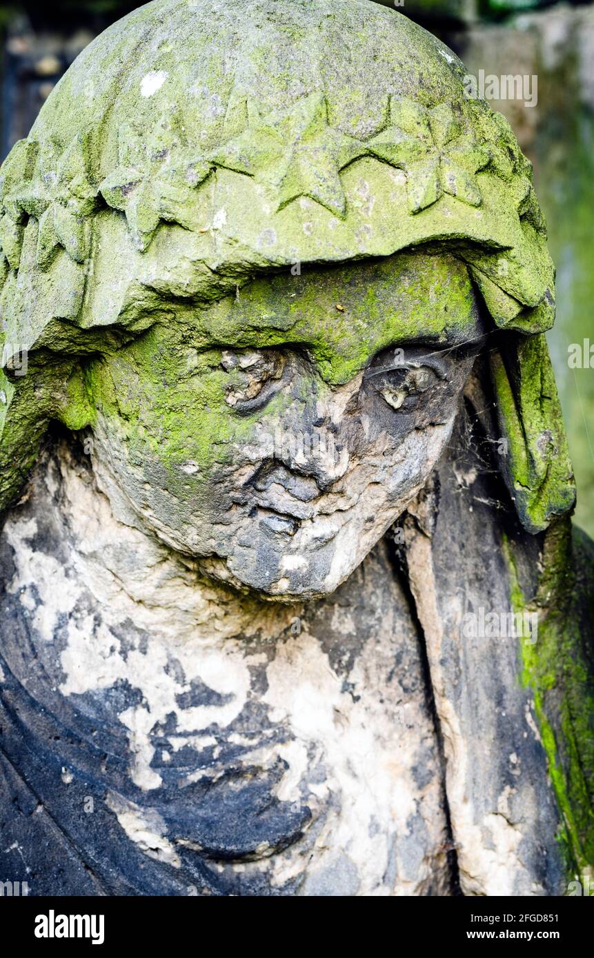 Statue of Mary (mother of Jesus) with damaged face - statue at old cemetery, Krasna Lipa, Czech republic, Europe Stock Photo