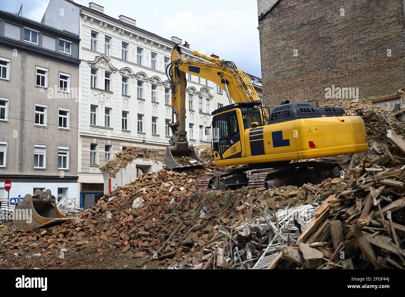 Earth moving machine tearing down an old building in Vienna Stock Photo