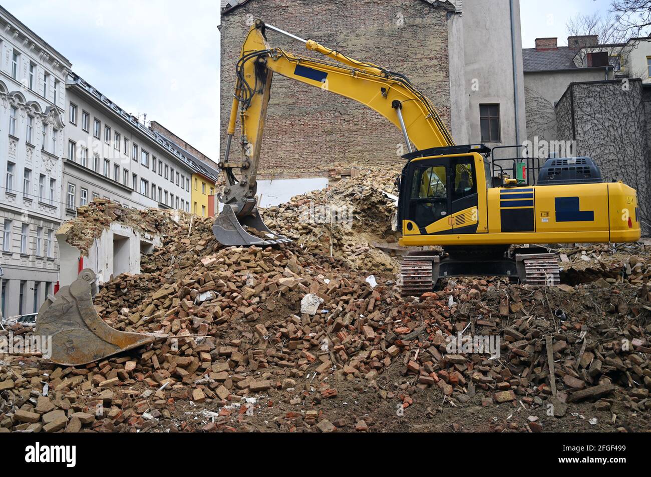 Earth moving machine tearing down an old building on a construction site Stock Photo
