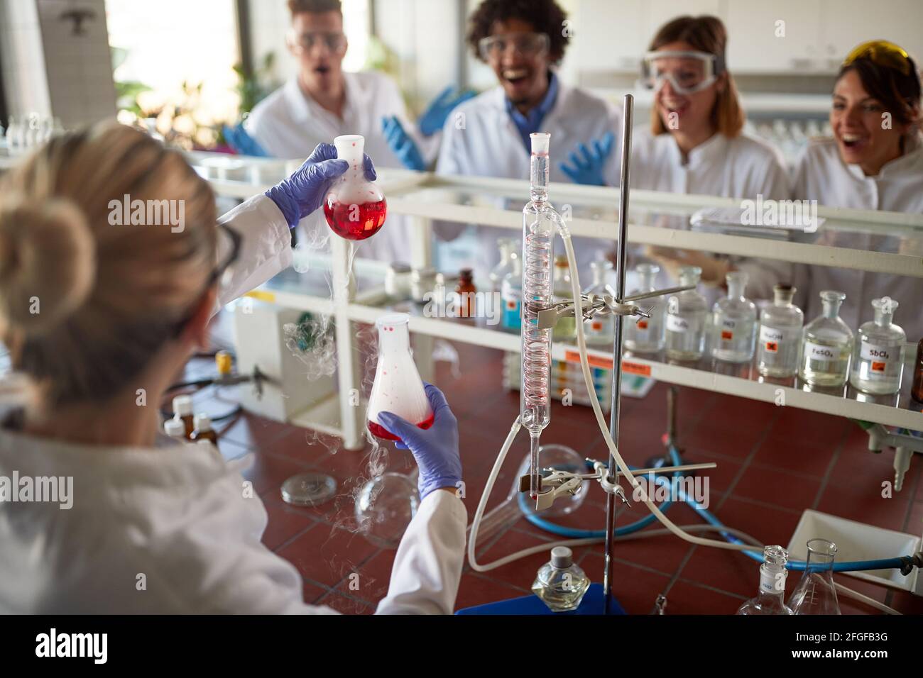 Young chemistry students are excited about experiment they doing in a laboratory in a cheerful atmosphere. Science, chemistry, lab, people Stock Photo