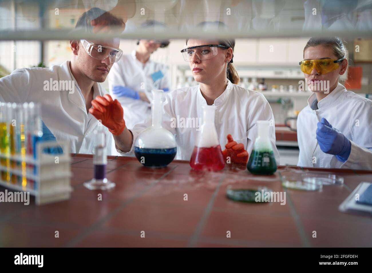 Young chemistry students work with dangerous chemicals in a working atmosphere in the university laboratory. Science, chemistry, lab, people Stock Photo