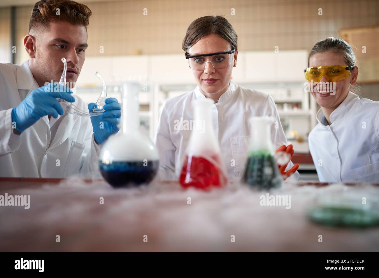 Young chemistry students are excited about a chemical reaction in an experiment in a relaxed atmosphere at the university laboratory. Science, chemist Stock Photo